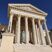 a building with columns and a clock on the front of it
