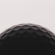 a close up of a black golf ball