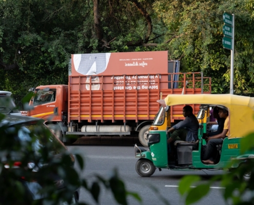 a green and yellow truck driving down a street