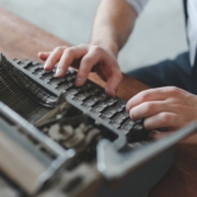 a man typing on an old fashioned typewriter