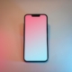 A pink and white cell phone sitting on top of a table