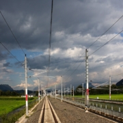 a train track running through a lush green field