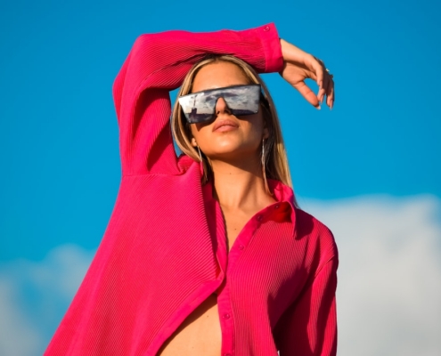 a woman wearing a red hoodie and sunglasses