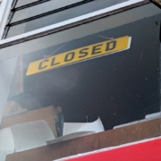 A yellow sign reads closed in a window.
