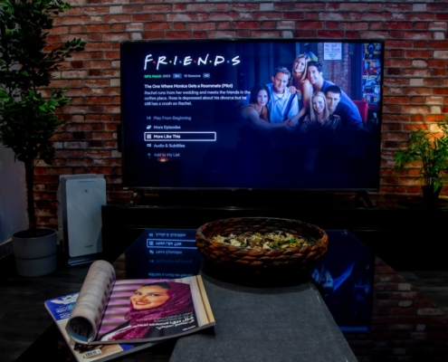 black flat screen tv turned on near brown brick wall