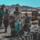 construction workers standing near wheelbarrows near mountain