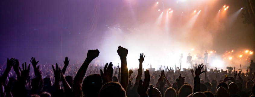 crowd facing lighted stage