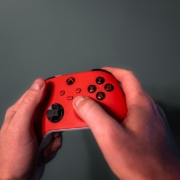 Hands holding a red video game controller