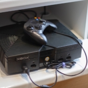 Here's a caption: an original xbox console with a controller.