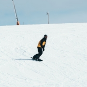 man in black jacket and black pants walking on snow covered ground during daytime