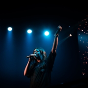 man in black t-shirt singing on stage
