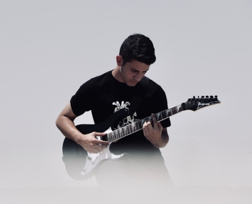 man playing black and white electric guitar