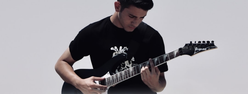 man playing black and white electric guitar