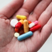 orange and white medication pill on persons hand