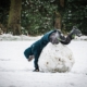 person in blue jacket and gray pants playing on snow covered ground during daytime