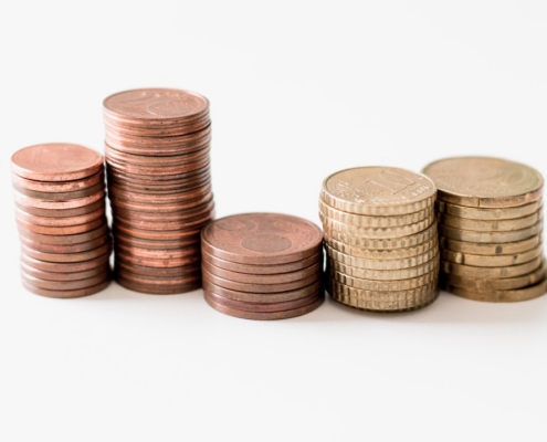 stacked round gold-colored coins on white surface
