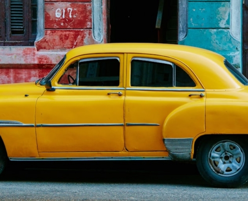yellow sedan parked near red concrete building