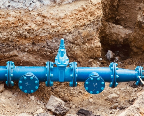 a blue pipe laying on top of a pile of dirt