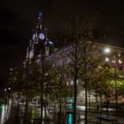 a city street at night with a clock tower in the background