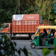 a green and yellow truck driving down a street