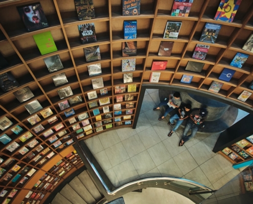 a group of people sitting on top of a book shelf