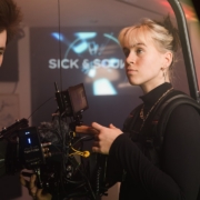 a man and a woman standing in front of a camera