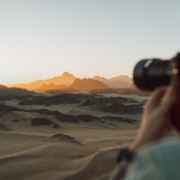 a woman taking a picture of the desert with a camera