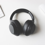 black wireless headphones between Apple Keyboard and Apple Magic Mouse on white surface