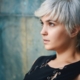 close up photography of woman wearing black sleeveless top leaning on gray concrete wall