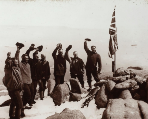 grayscale photo of men standing beside flag