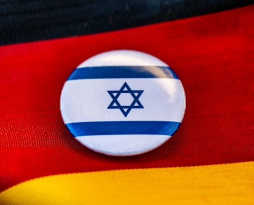 Israeli flag pin rests on german flag