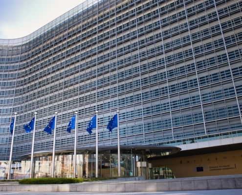 Modern glass building with european union flags