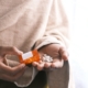orange and white plastic bottle on white textile