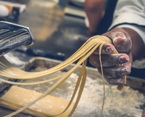 person sheeting dough