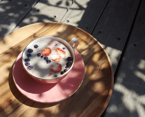 red and white ceramic mug on brown wooden round table
