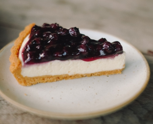 slice blueberry cheesecake pie on white ceramic plate