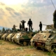 soldiers on top of battle tanks