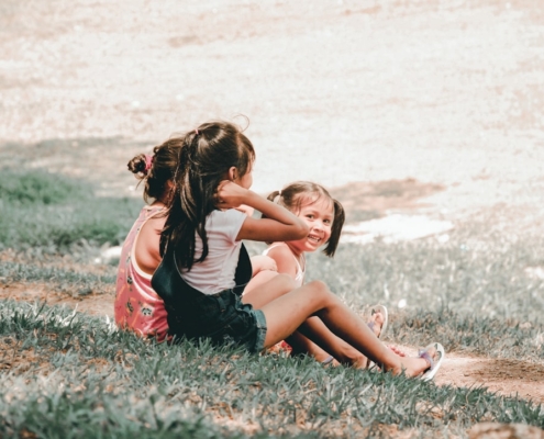 three children sitting on grass