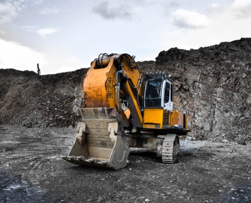 yellow and black excavator near hill