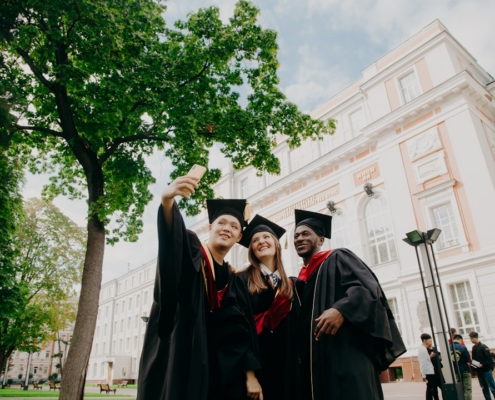3 women in black academic dress standing near green tree during daytime