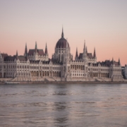 a body of water with a large building in the background with Hungarian Parliament Building in the background