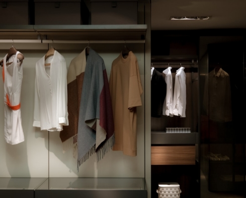 a bunch of clothes hanging on a rail in a closet