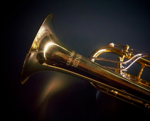 a close up of a brass trumpet on a black background