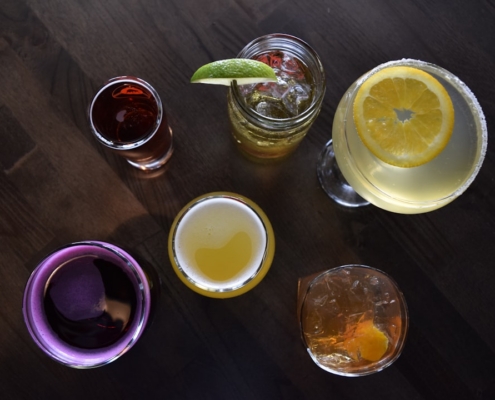 a group of glasses filled with different types of drinks
