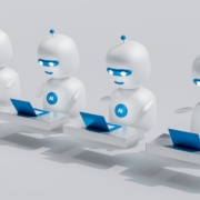 a group of white robots sitting on top of laptops