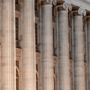 a large building with columns and a clock on the front of it