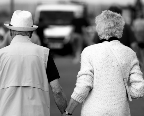 a man and a woman walking down a street holding hands