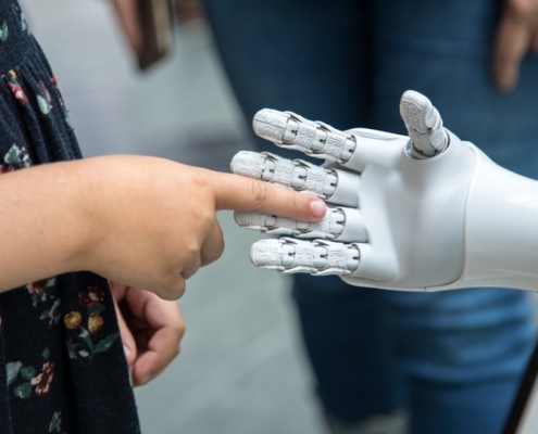 a person holding a robotic hand in front of a mirror