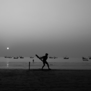 a person standing on a beach holding a bat