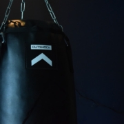 black leather boxing gloves hanging on white metal bar